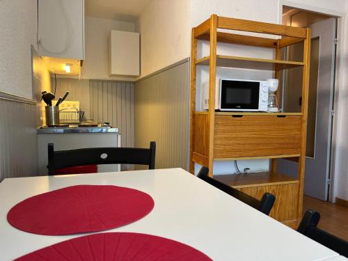 um quarto com uma mesa e uma cozinha com um micro-ondas em Appartement Pra-Loup, 2 pièces, 4 personnes - FR-1-165A-82 em Uvernet