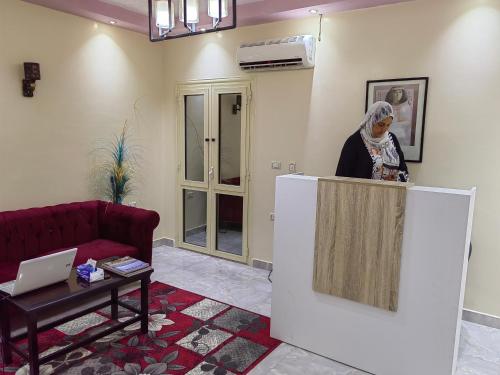 a woman standing behind a counter in a living room at Gem Overlooking inn in Cairo