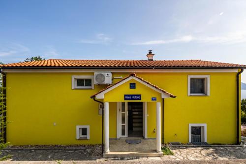a yellow house with a door in front of it at Seaview House Helena Apartments - Happy Rentals in Plomin