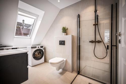 a bathroom with a toilet and a washing machine at Corner Apartments in Bergen