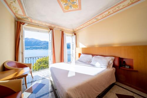 a bedroom with a bed and a large window at Hotel San Rocco in Orta San Giulio