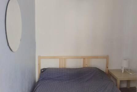 um pequeno quarto com uma cama e uma mesa em Chiado / Carmo Small Artist Lodge em Lisboa