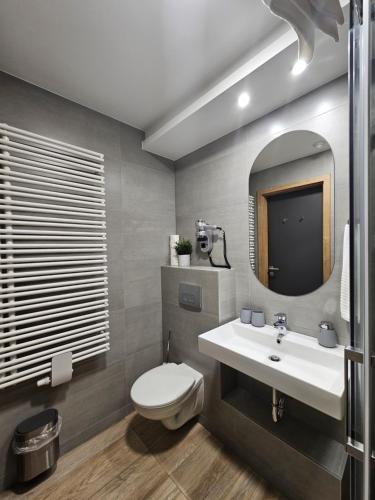 a bathroom with a toilet and a sink and a mirror at Minaret Residence & Relax Pécs in Pécs