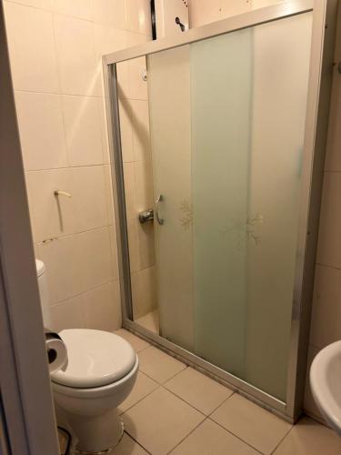 a bathroom with a toilet and a glass shower at Efe Can Apart Otel in Canakkale