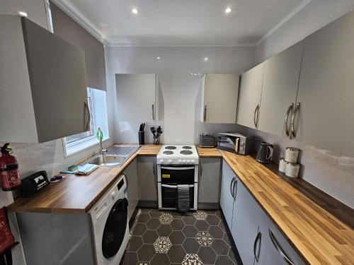 a small kitchen with a stove and a sink at 31 Westmorland Street by Prestige Properties SA in Barrow in Furness