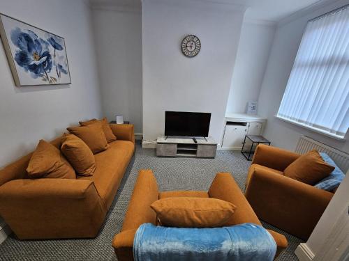 31 Westmorland Street by Prestige Properties SA في بارو في فرنيس: غرفة معيشة مع كنب وتلفزيون بشاشة مسطحة