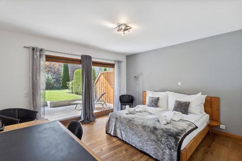 a bedroom with a bed and a table and a window at The Lodge by Mrs Miggins in Champéry