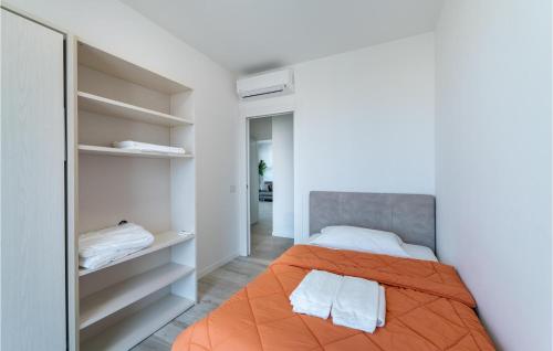 - une chambre avec un lit orange et un placard dans l'établissement Amazing Apartment In San Benedetto Di Lugan With Outdoor Swimming Pool, à Peschiera del Garda