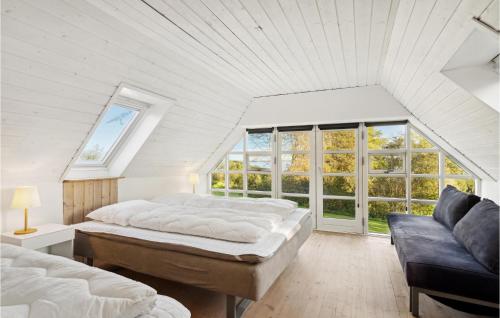 a white attic bedroom with two beds and a couch at Pet Friendly Home In Lgstrup With Kitchen in Løgstrup