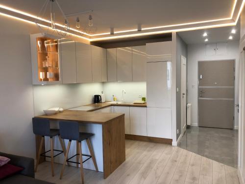 a kitchen with white cabinets and a wooden counter top at Wolf Apartment in Kłodzko