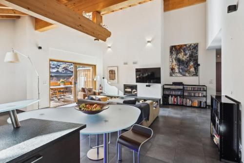 a kitchen and living room with a table and chairs at The Lodge by Mrs Miggins in Champéry
