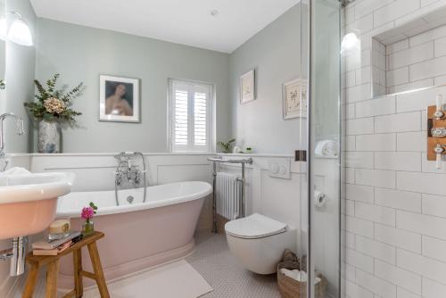 a bathroom with a tub and a toilet and a sink at Little Dorset Cottage in Milton Abbas