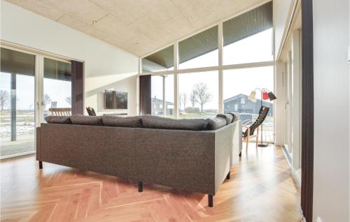 DiernæsにあるCozy Home In Haderslev With Wifiの大きな窓のある客室で、大きなソファが備わります。
