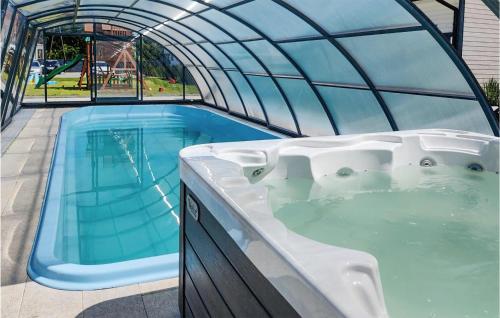 a hot tub in a greenhouse next to a swimming pool at Stunning Home In Jantar With Heated Swimming Pool in Jantar