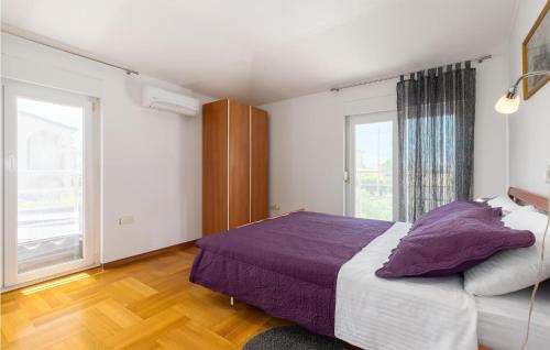 a bedroom with a large bed and a large window at Awesome Apartment In Porec With Kitchen in Žbandaj