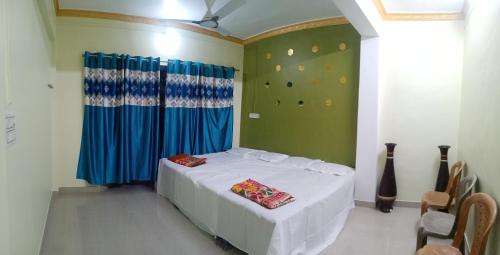 una camera con letto bianco con tenda blu di Omkar Holiday Home Revdanda a Revadanda