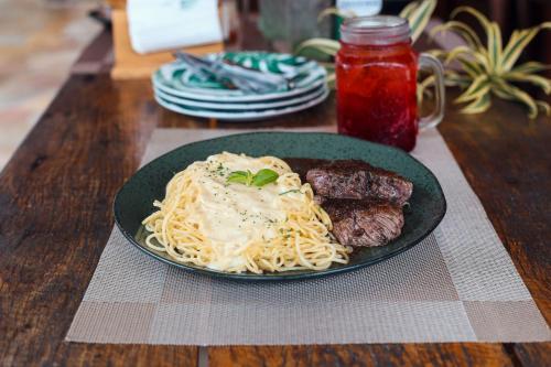 a plate of pasta with meat and sauce on a table at Pousada Porto Mare in Maresias