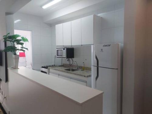 kuchnia z białymi szafkami i lodówką w obiekcie PHD - Personal Home Design w São Paulo