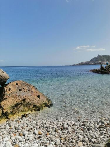 a rocky beach with a large rock in the water at "Seaside Studio with Stunning Views in Belyounech in Belyounech 