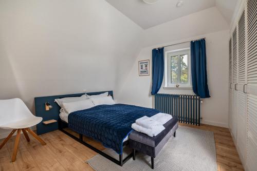a bedroom with a blue bed and a window at Apartment Wilhelm in Nienburg