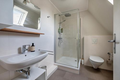 a white bathroom with a sink and a shower at Apartment Wilhelm in Nienburg