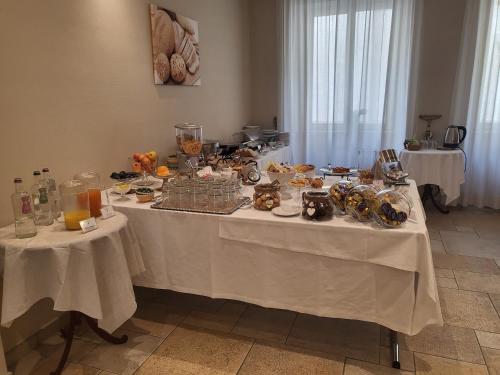 a table with food and other items on it at Hotel Lux in Alessandria