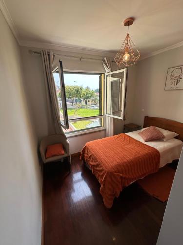 een slaapkamer met een bed en een groot raam bij Apartamento Santiago I in Funchal