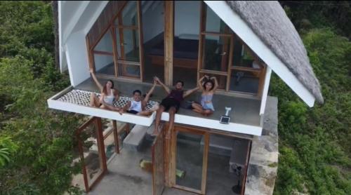 um grupo de pessoas sentadas na varanda de uma casa em Villa Zalakain em Siquijor