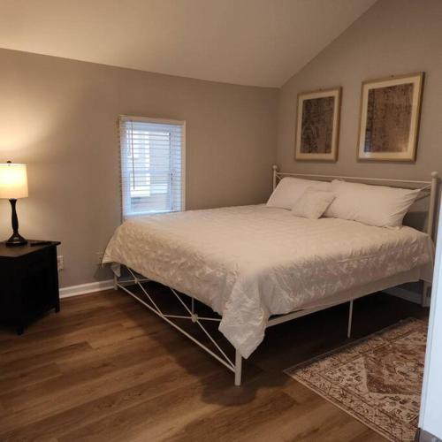 a bedroom with a bed and a lamp and a window at Stylish Cottage Near Airport in Atlanta