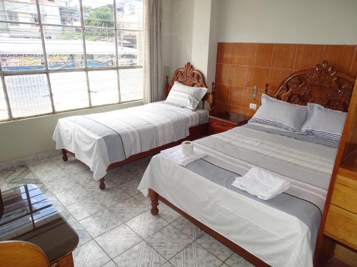 1 dormitorio con 2 camas y ventana en HOSTAL RESIDENCIAL UCAYALI en Tingo María