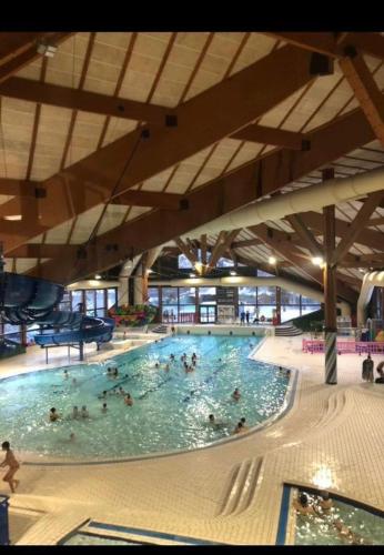 une grande piscine avec de nombreuses personnes dans l'établissement Charmant studio au pieds des remontées mécaniques., à Villard-de-Lans