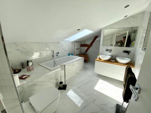 a white bathroom with a tub and a sink at Villa Iduna mit modern desingten Apartments in Graal-Müritz