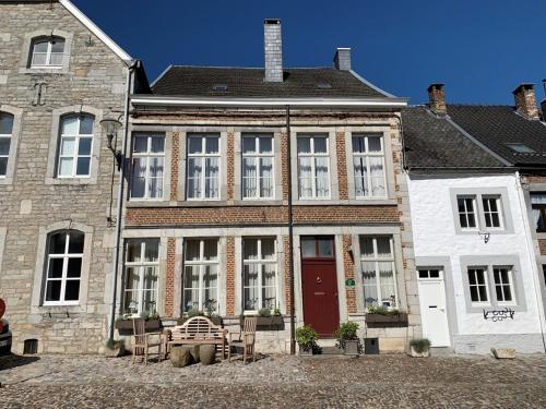 uma grande casa de tijolos com uma porta vermelha em Gite de Caractère Le Lys Bleu em Limbourg