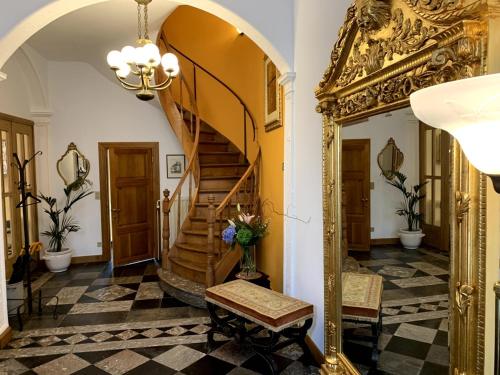 a hallway with a spiral staircase and a mirror at Gite de Caractère Le Lys Bleu in Limbourg