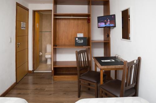 ein kleines Zimmer mit einem Tisch und einem Zimmer mit einem WC in der Unterkunft Hotel Premier Bariloche in San Carlos de Bariloche