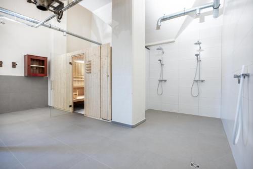 La salle de bains est pourvue de murs blancs et d'une cabine de douche. dans l'établissement Krusespeicher Krusespeicher 3-50, à Wismar