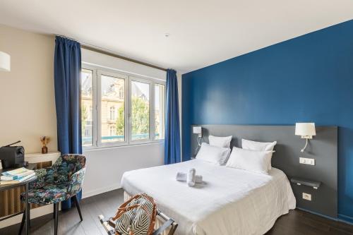 a hotel room with a bed and a window at Hotel-Restaurant Le Victoria in Rennes