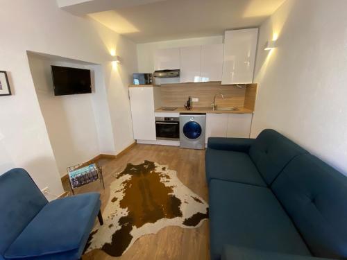 a living room with a blue couch and a kitchen at Appartement Doria in Saint-Florent
