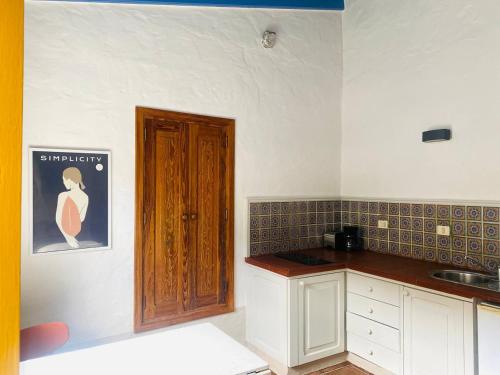 a kitchen with a sink and a wooden door at Finca Origen · Casa Trinidad · Rural· Unique in San Pedro