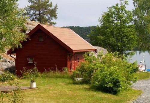 a small red cabin on the side of a lake at Risør Gjestehus in Risør
