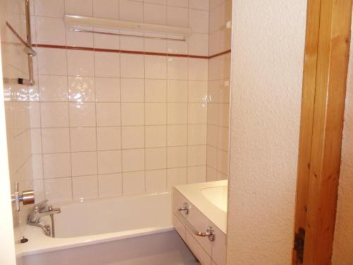 une salle de bain avec une baignoire et un lavabo dans l'établissement Studio divisible 4 pers, centre station, balcon sud, proche pistes, animaux admis - FR-1-181-2699, à La Plagne Tarentaise