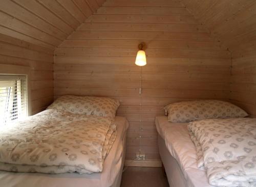 リソルにあるRisør Gjestehusの木造キャビン内のベッドルーム1室(ベッド2台付)