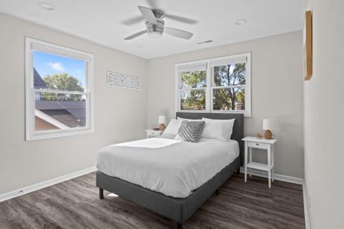 a white bedroom with a bed and two windows at The Sanctuary - Work Friendly & Near Downtown in Indianapolis