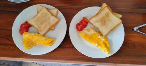 twee witte borden met ontbijt op tafel bij Tamansari Homestay in Sawan