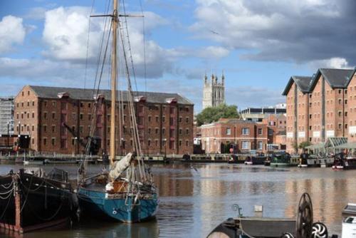 a boat is docked in the water in a harbor at Elliot Oliver - Luxurious Two Bedroom Apartment in The Docks in Gloucester