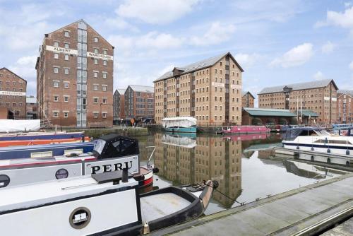 a group of boats docked in a harbor with buildings at Elliot Oliver - Luxurious Two Bedroom Apartment in The Docks in Gloucester