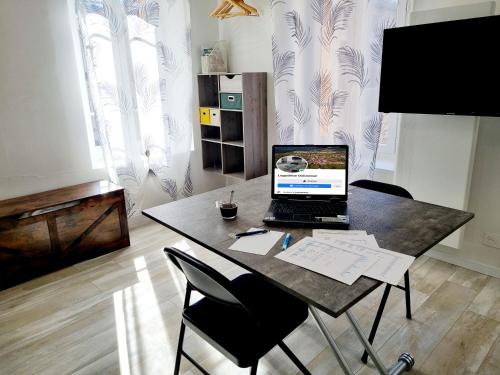 a laptop computer sitting on a table in a room at Ecouter le silence à LALOUVESC in Lalouvesc