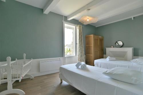1 dormitorio con 2 camas y 1 cuna en Ker Gheal - Jolie maison bretonne, en Plévenon
