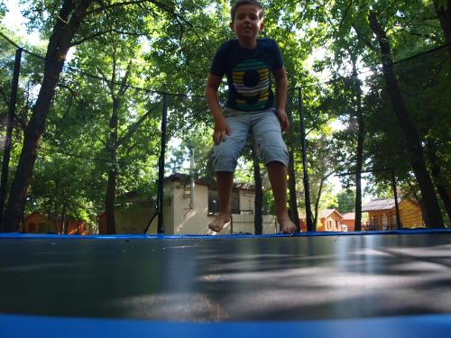a young boy is standing on a tennis court at Árnyas Thermal Camping és Üdülőpark in Püspökladány