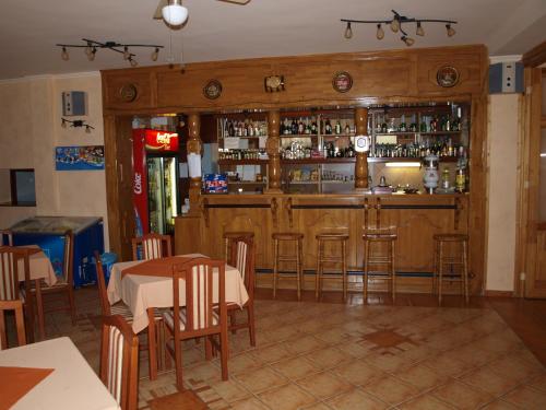 a restaurant with a bar with a table and chairs at Árnyas Thermal Camping és Üdülőpark in Püspökladány